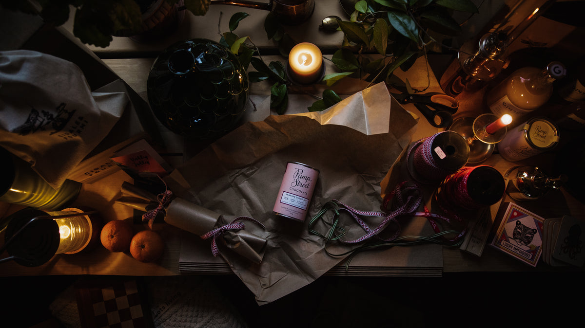 Wrapping paper, ribbon and candles on a table prepared for Christmas gifts