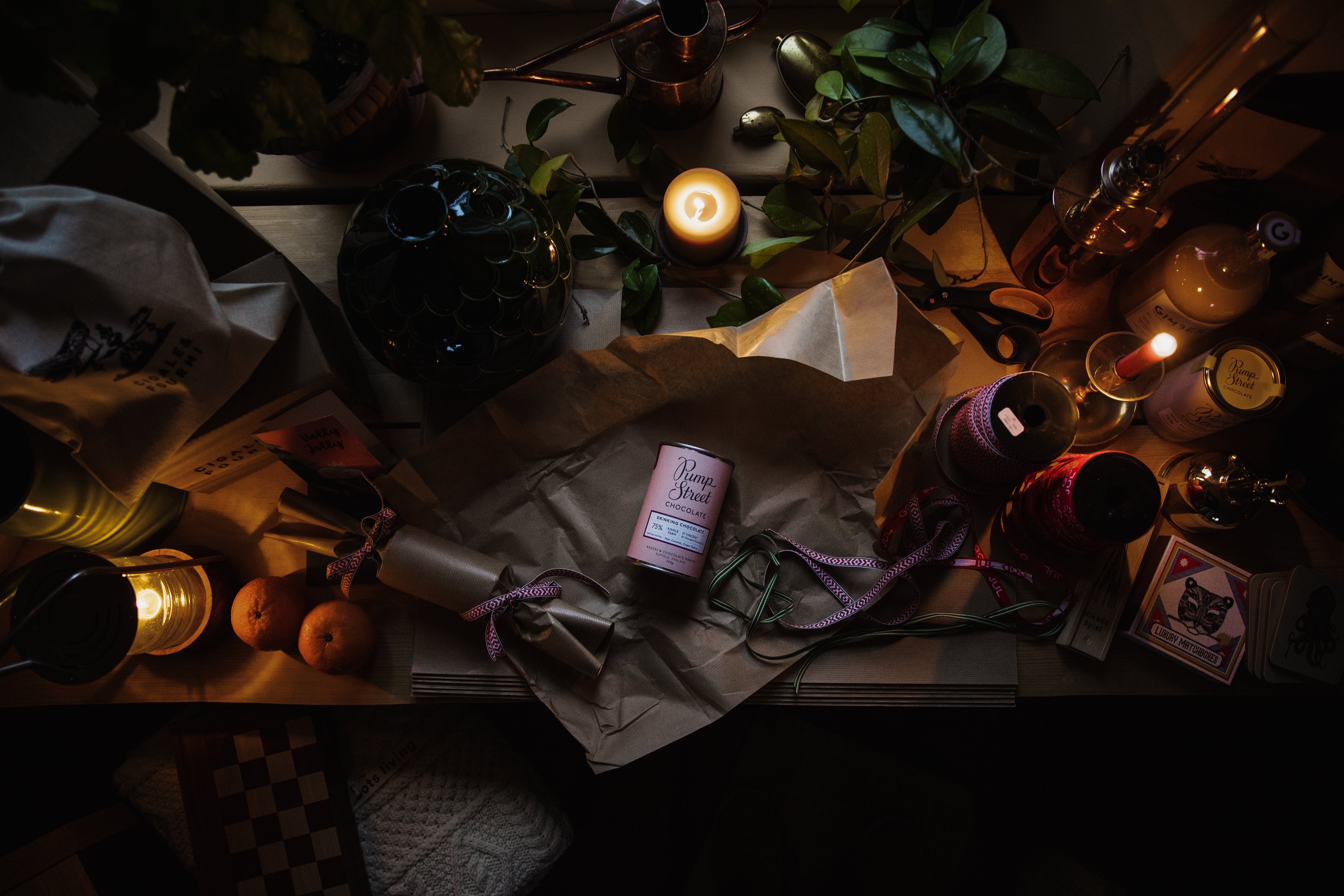 Wrapping paper, ribbon and candles on a table prepared for Christmas gifts